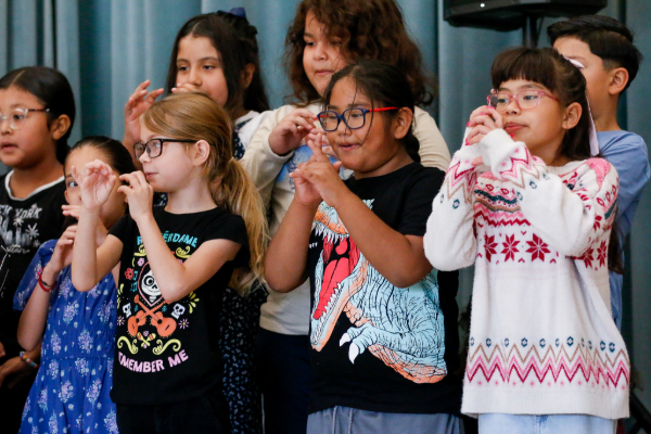 Second grade students pretend to play instruments