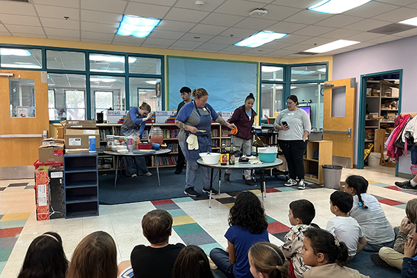 A woman does a cooking demonstration for students