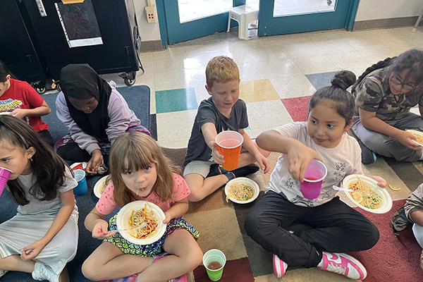 Students enjoy their bowls of snap pea pancit