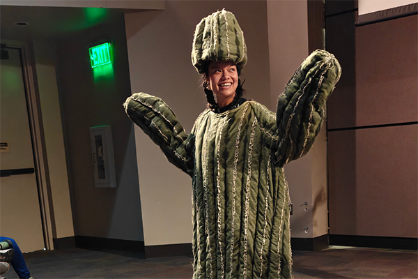 A girl dressed up as a saguaro cactus
