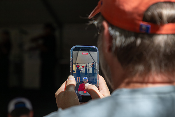 A man takes a video of the mariachi performance on his phone