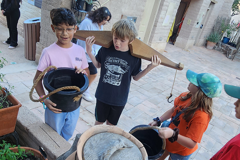 Students hold up old-fashioned buckets