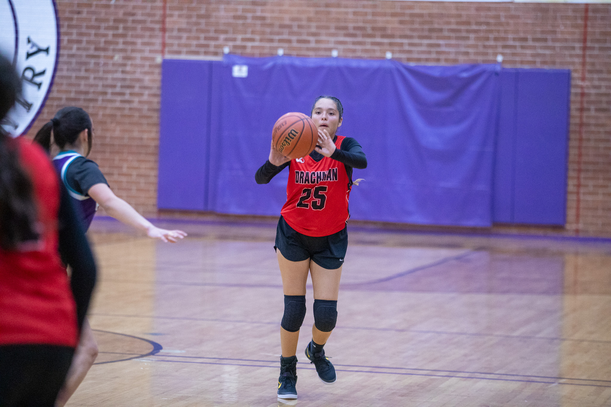 A girl passes the basketball to a teammate