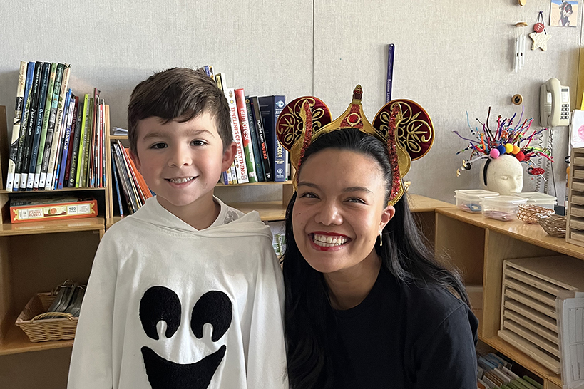 A little boy dressed as a ghost and his teacher wearing Mickey Mouse ears