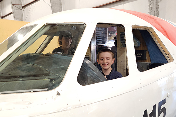 Two students sit in the cockpit of a plane