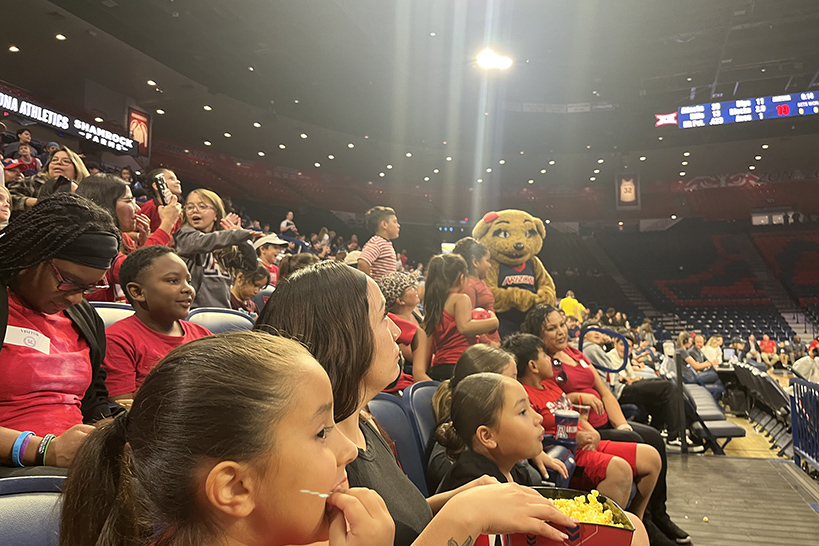 Students sit in the stands watching the game
